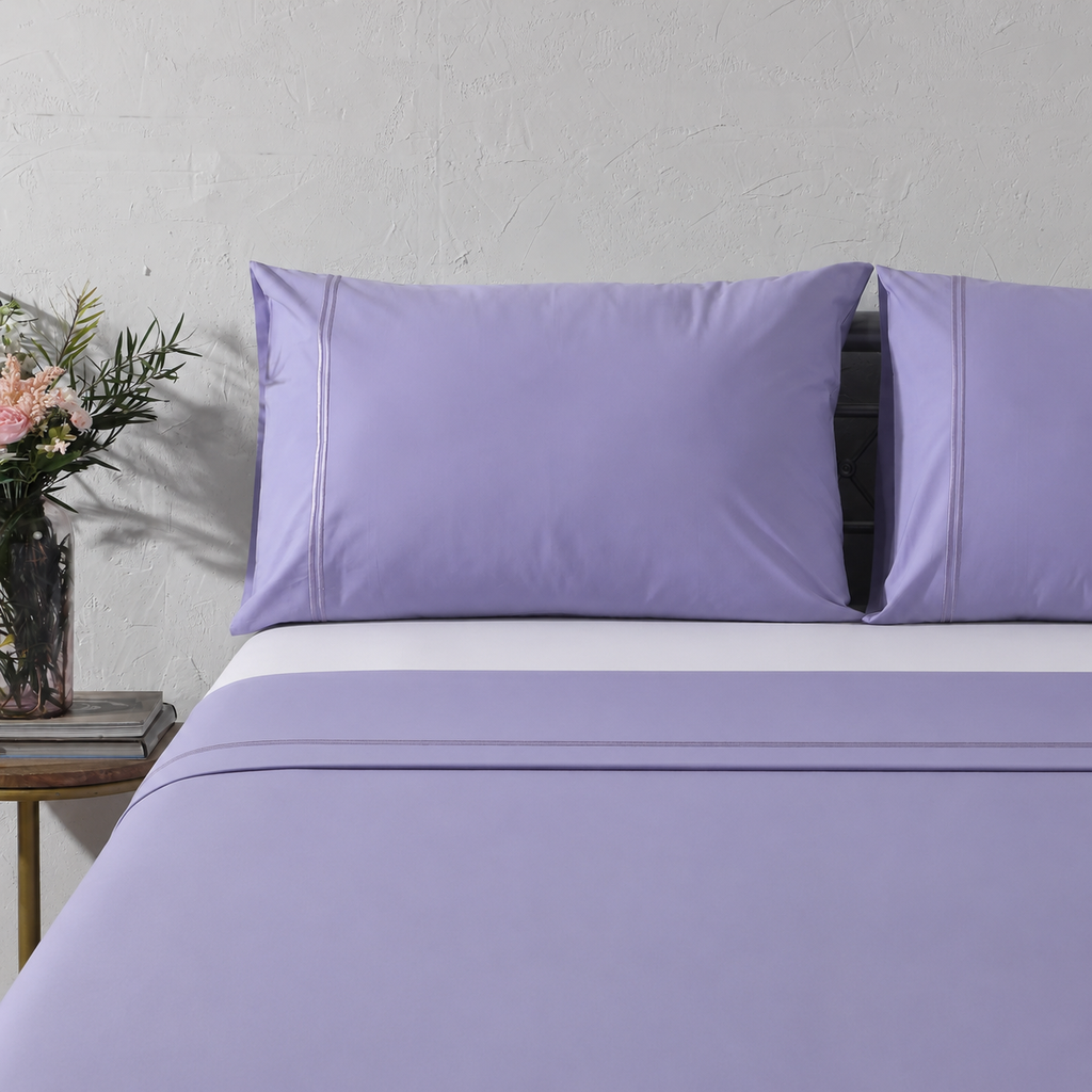 Full bed angled shot with Lavender Mist bedding, flowers and side table: 250TC GOTS certified Organic Cotton Coloured Sheet Set Lavender Mist embroidered full bed styling Whites of London New Zealand and Fitted sheet