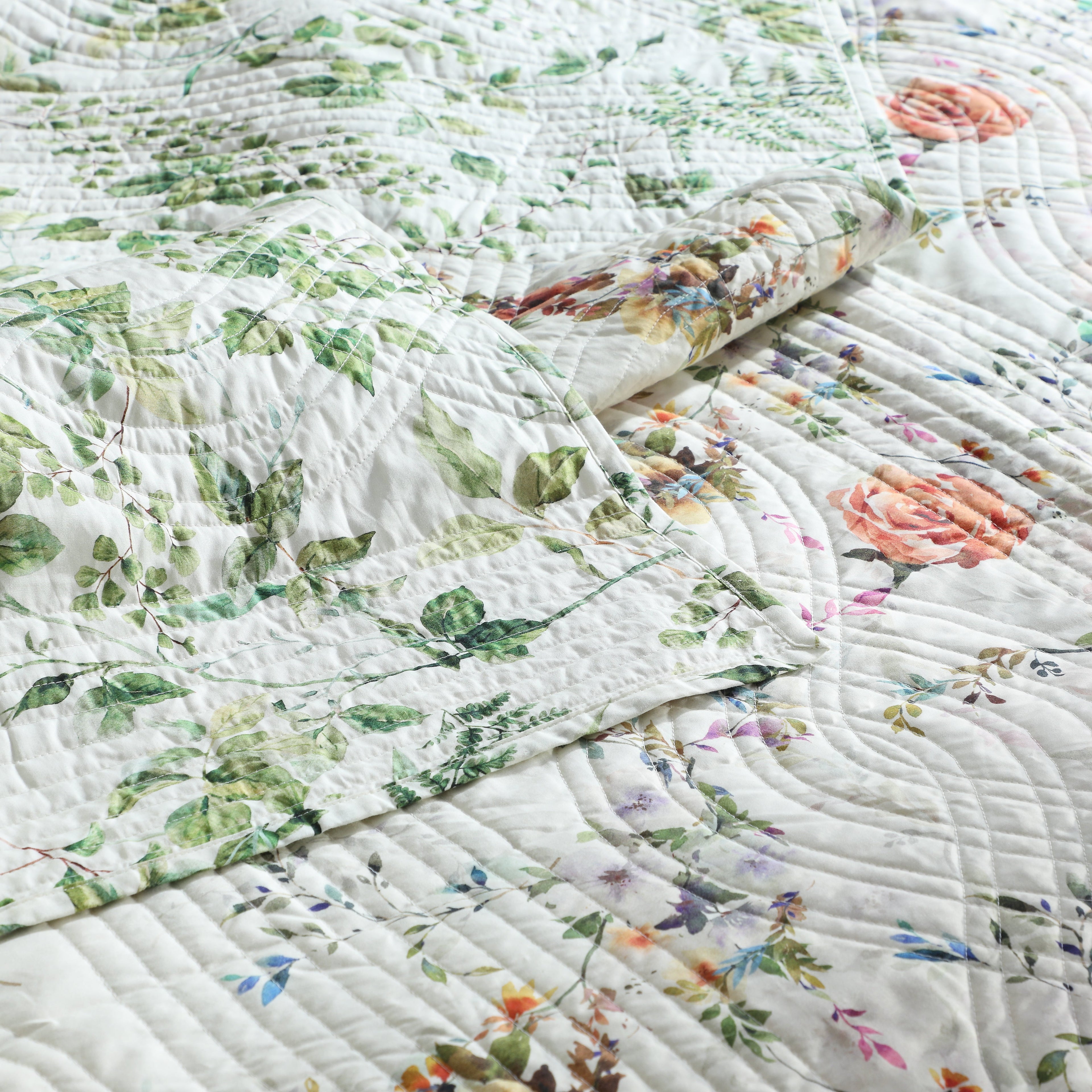 organic floral quilted dohar with green leaves and colourful flowers.