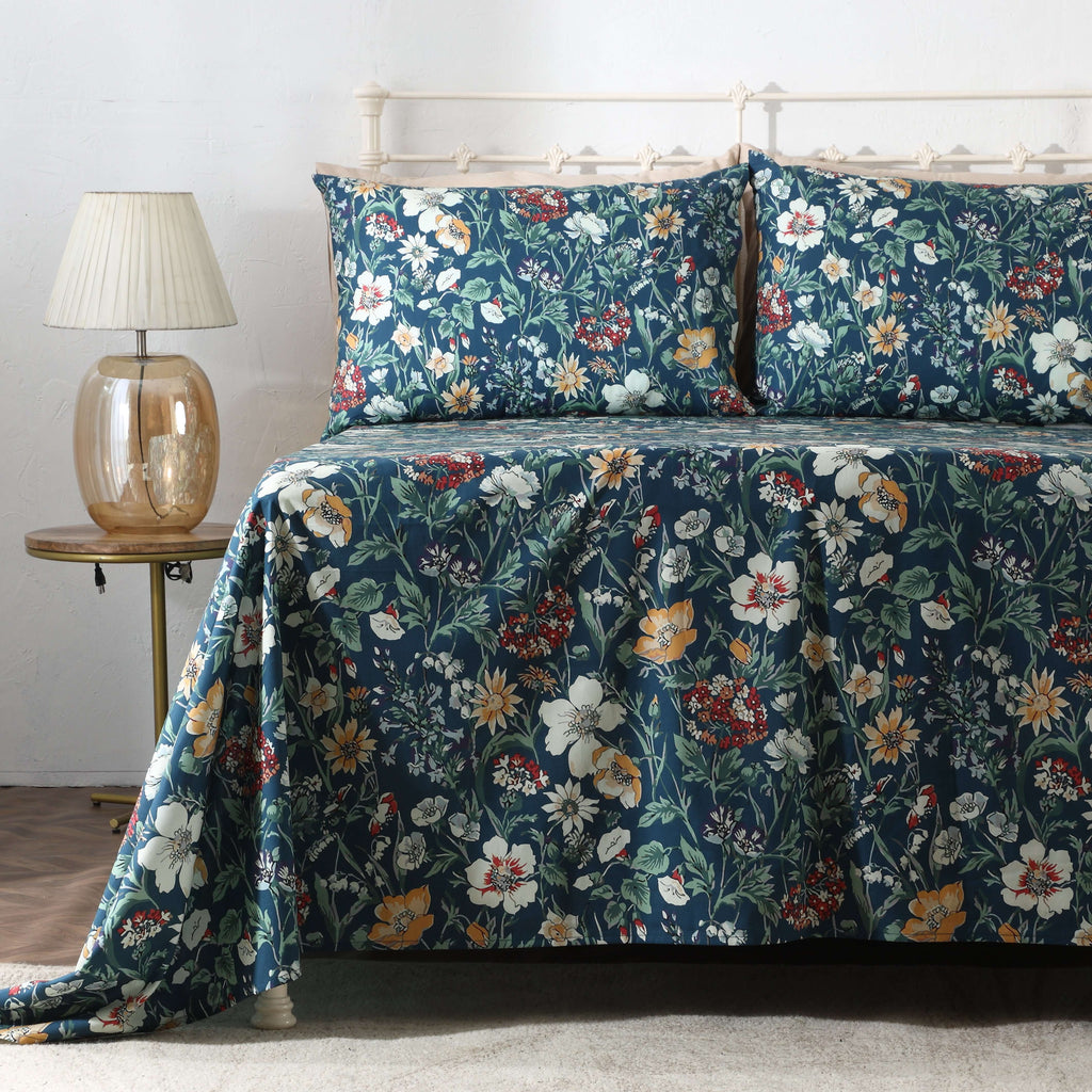 Left side view of Adriana Blue 250TC GOTS certified organic cotton percale printed sheet set on bed, highlighting blue floral print and delicate leafy details