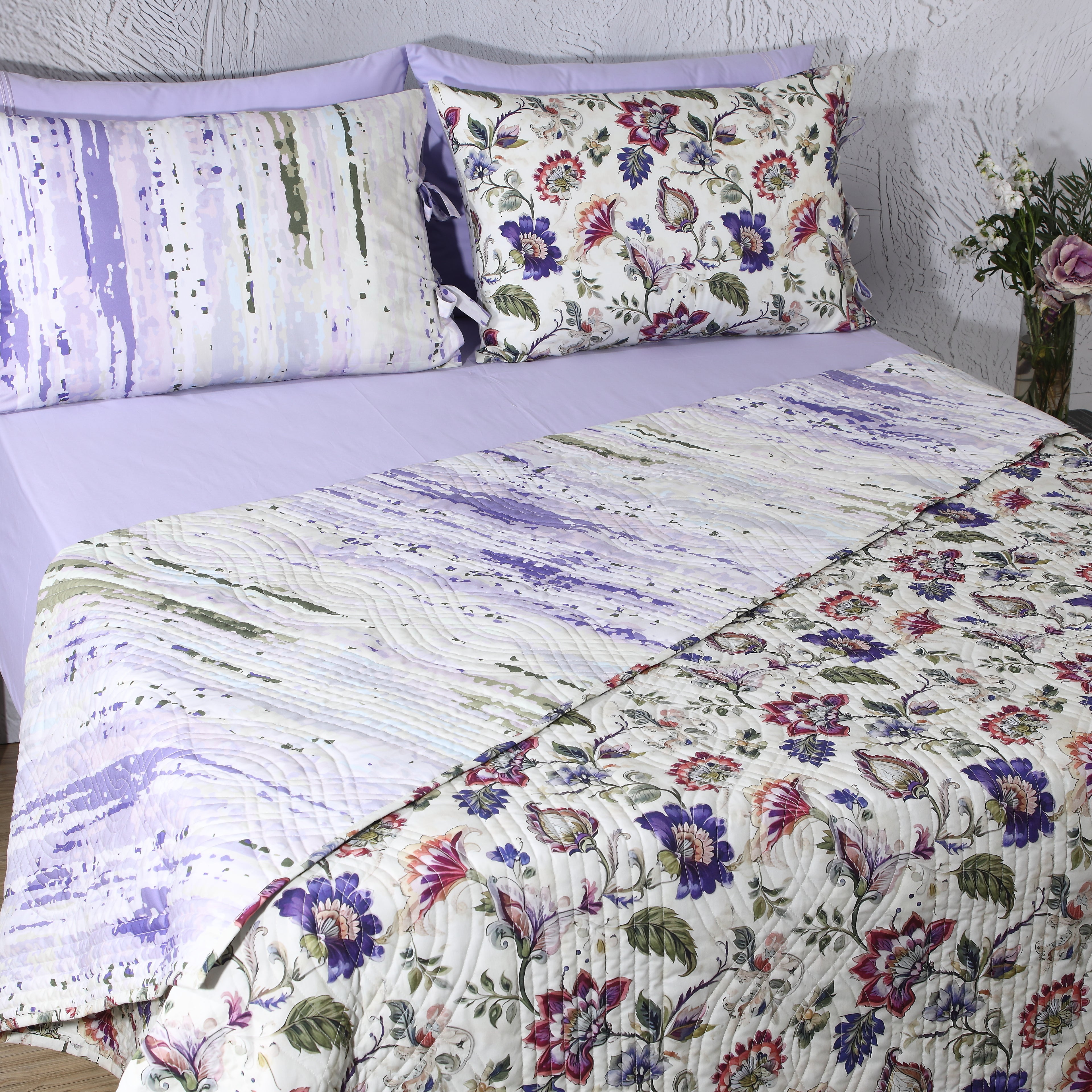 Wide bedroom view of Lavender Fields percale reversible quilt set  with matching reversible pillowcases on styled bed