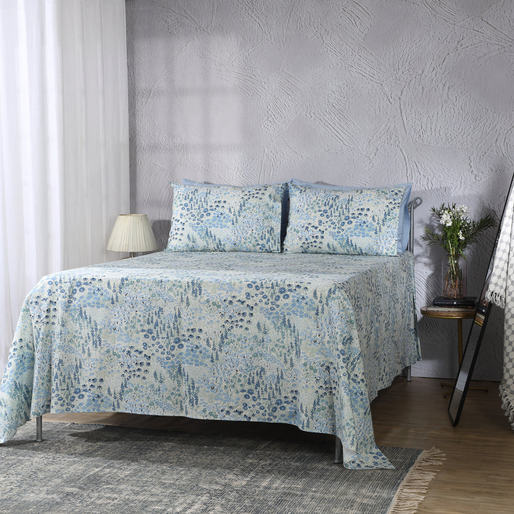 Wide bedroom lifestyle shot with full sheet set visible: Windflower GOTS certified organic cotton percale printed sheet set blue floral printed sheet set bedroom lifestyle Whites of London NZ