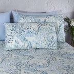 Close-up of Windflower blue floral pillowcases on bed, part of 250TC GOTS certified organic cotton percale printed sheet set