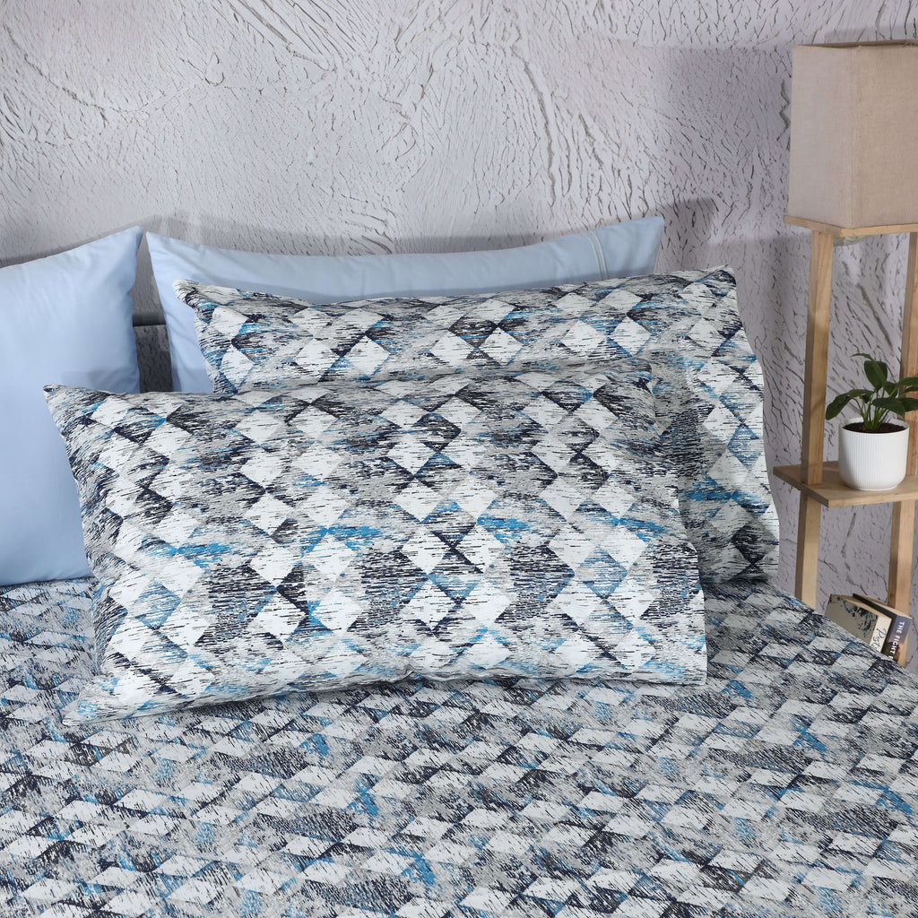 Whites of London Two pillowcases on bed with matching blue, slate, and grey geometric sheets GOTS certified organic cotton percale printed sheet set New Zealand and Australia