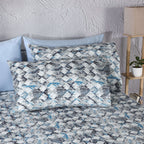 Whites of London Two pillowcases on bed with matching blue, slate, and grey geometric sheets GOTS certified organic cotton percale printed sheet set New Zealand and Australia