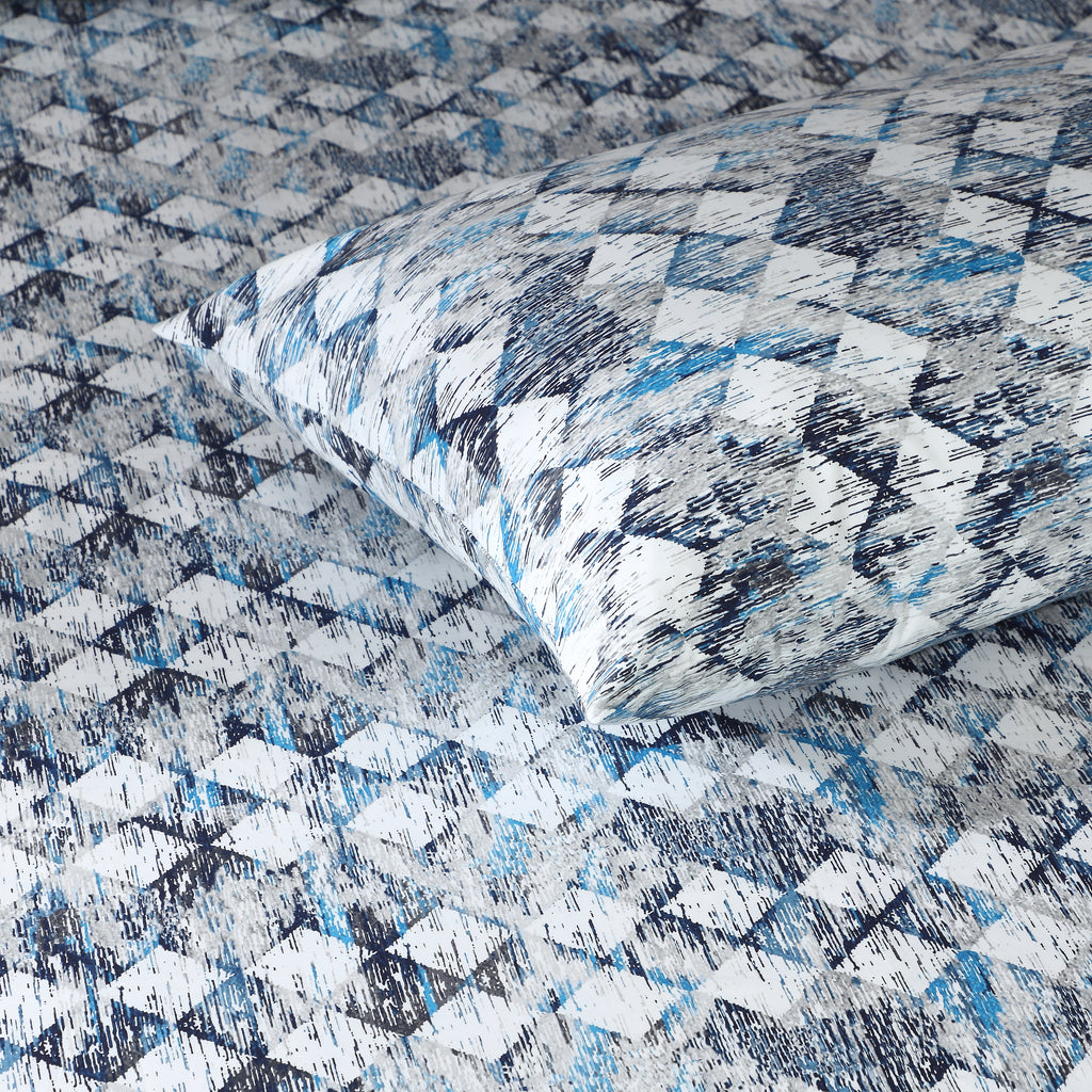 Whites of London Close-up of single pillowcase on bed showing matching blue, slate, and grey geometric print GOTS certified organic cotton percale printed sheet set Australia 