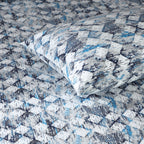 Whites of London Close-up of single pillowcase on bed showing matching blue, slate, and grey geometric print GOTS certified organic cotton percale printed sheet set Australia 