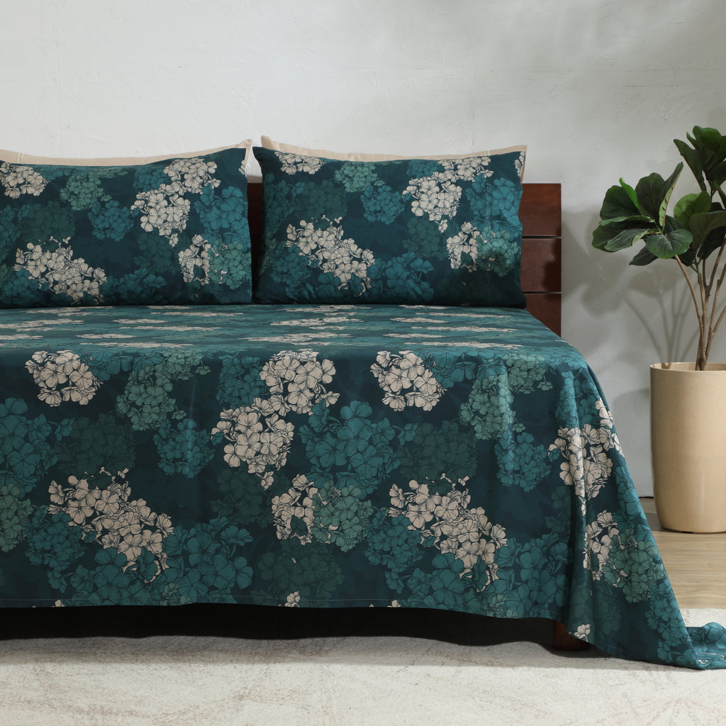 Right-side view of Hydrangea teal pillowcases on bed, part of 250TC GOTS certified organic cotton percale printed sheet set