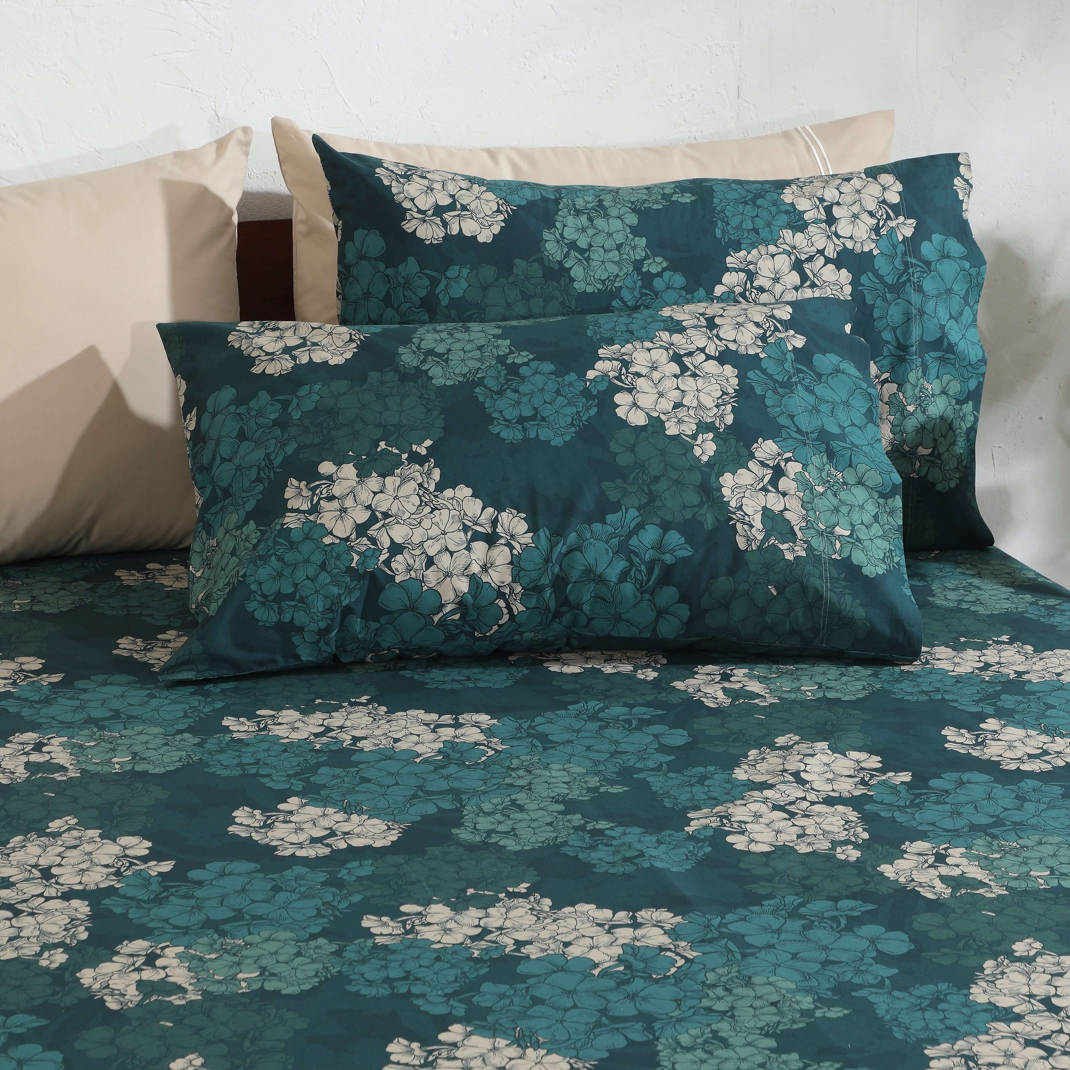 Hydrangea teal floral pillowcases styled on bed, 250TC GOTS certified organic cotton percale printed sheet set close-up