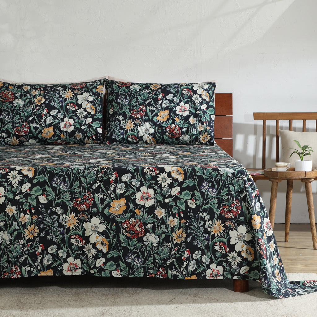 Right side view of Adriana Black 250TC GOTS certified organic cotton percale printed sheet set on bed, showing black floral pattern with layered blooms and leafy details
