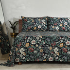 Left side view of Adriana Black 250TC GOTS certified organic cotton percale printed sheet set on bed, highlighting black floral print with ivory, ochre, sage, and crimson flowers