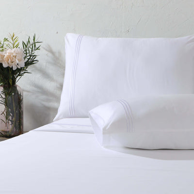 Close up of pillowcase and folded flat sheet with triple cord embroidery: 1250TC GOTS certified Organic Cotton Sheet Set white pillowcase flat sheet detail and Organic Cotton Fitted Sheet Whites of London 