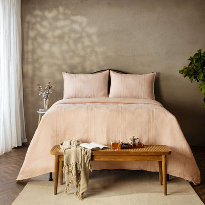 Peach Blossom pure linen duvet cover set on full bed with iron headboard and bench. European French flax 